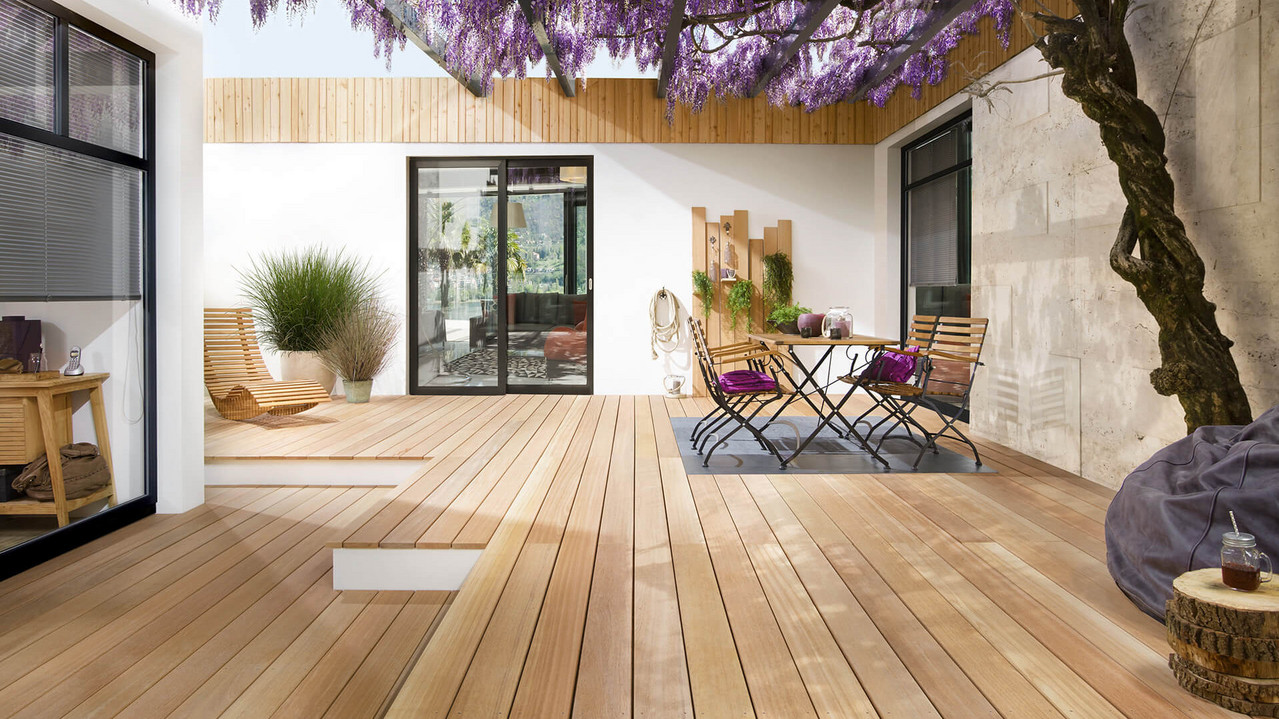 Gemütlicher Garten mit Pflanzdach und hellen Terrassendielen aus Holz